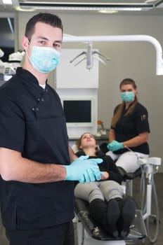 Dentist in the front, nurse and patient in the background