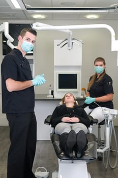 Dentist in the front, nurse and patient in the background