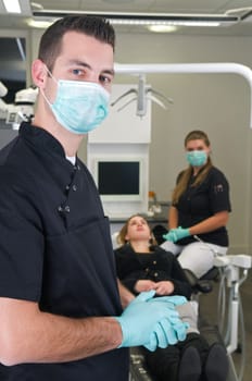 Dentist in the front, nurse and patient in the background