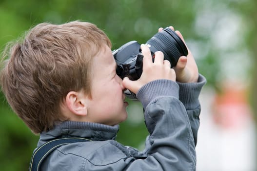 Young boy, nine years old, already practicing with an SLR shooting pictures of nature.