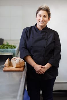 A female chef standing next to sliced bread