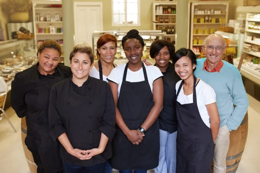 A group of deli workers standing in their shop