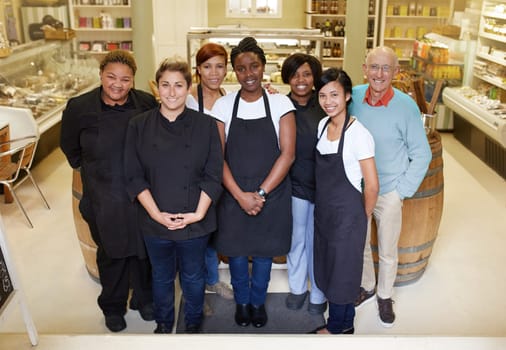 A group of deli workers standing in their shop