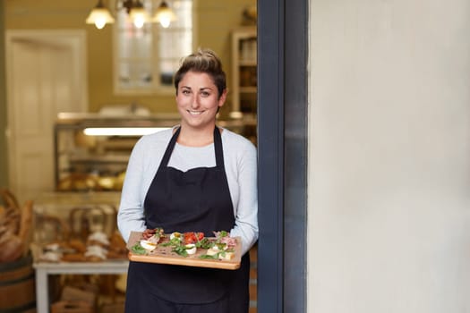 A young female deli employee standing in the doorway
