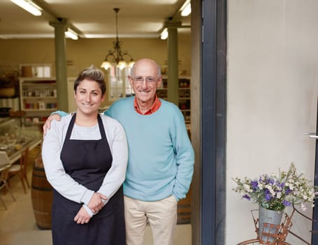 A deli owner and his daughter standing in their shop