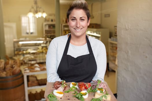 A female deli worker bringing you a snack plate