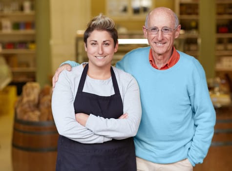 A deli owner and his daughter standing in their shop