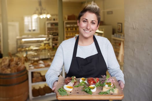 A female deli worker bringing you a snack plate