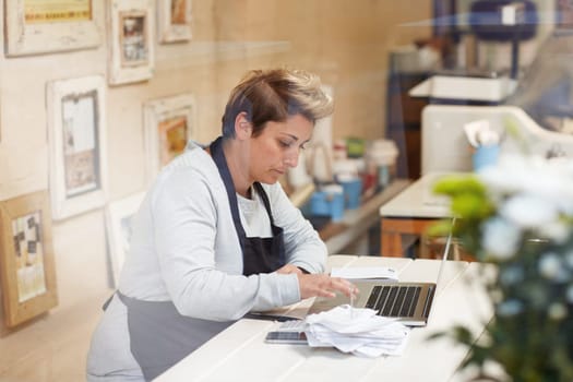A female deli owner doing her taxes in her shop
