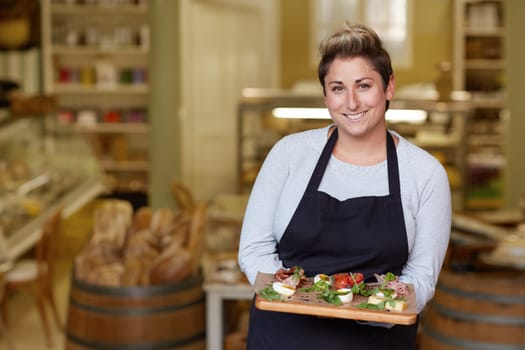 A female deli worker bringing you a snack plate