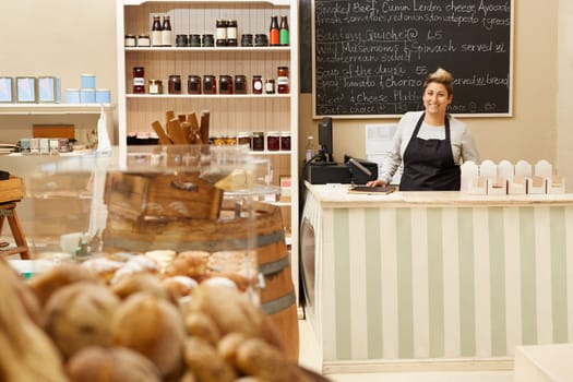 A young deli worker standing behind the counter