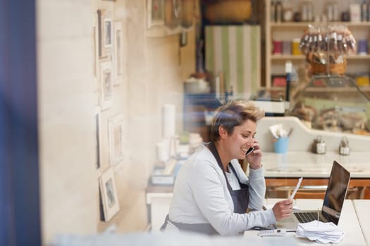 A female deli owner doing her taxes in her shop