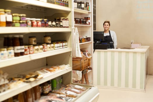 A young deli worker standing behind the counter