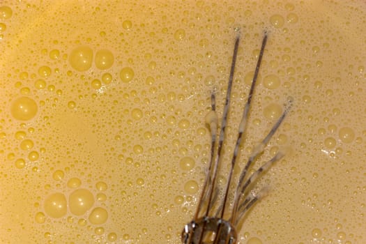 Pancake liquid ready to be baked with stainless steel metal eggs stirrer tool