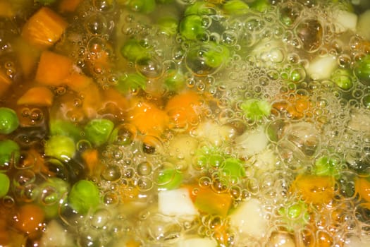 Closeup of cooking various vegetables. Lots of bubles are visible