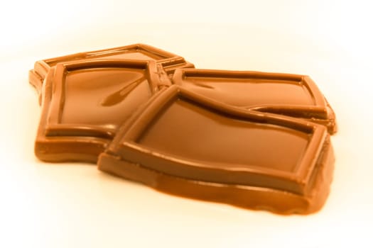 Melted squares of chocolite on white background