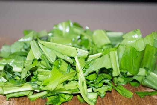 Healthy green salad on wooden plate ready to be eaten