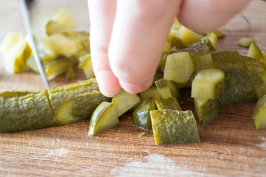 Closeup of pickles beeing cutted with knife.