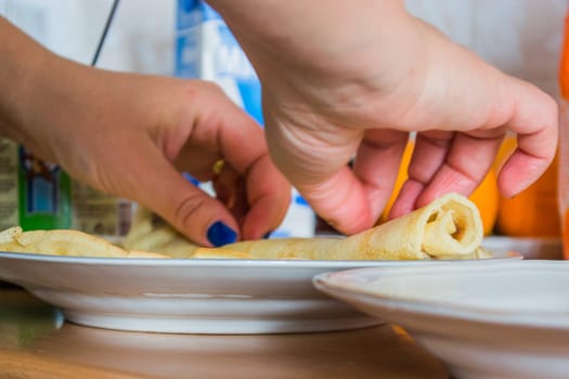 Aranging pancakes on a plate in the kitchen