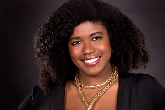 beautiful young black woman is wearing dark dress on grey background
