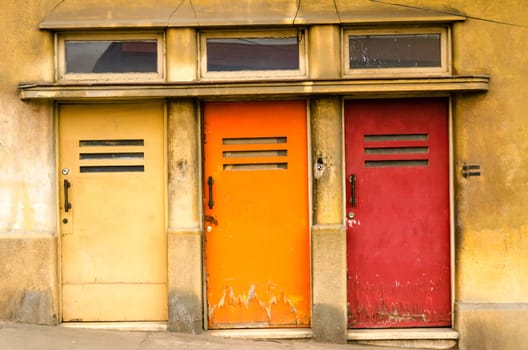 Three doors colored yellow, orange, and red in Valparaiso, Chile