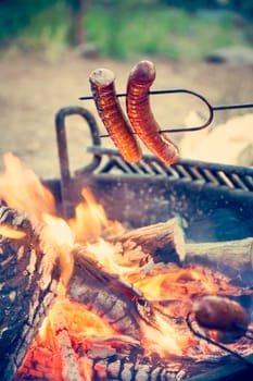 Preparing sausage on campfire