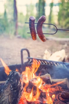 Preparing sausage on campfire