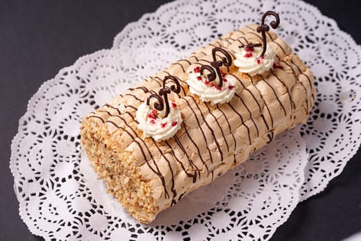 pastry biscuit roulade with whipped cream and chocolate scrolls ready for serving to the teaparty