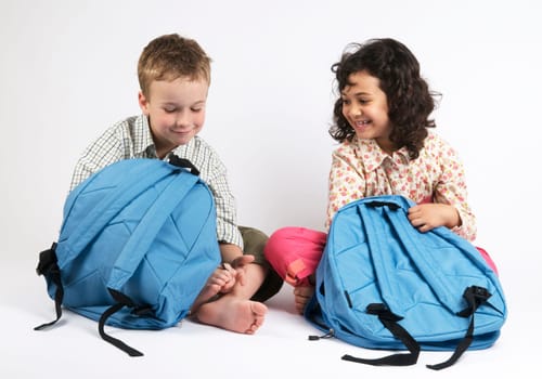Two kids going on a vacation packing their backpacks. Or use it as two kids packing for school...