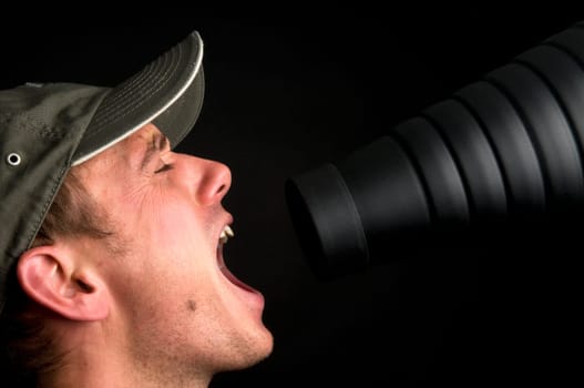 Man singing in front of a snoot, against a black background.