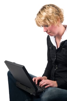 Beautiful girl sitting on the floor with a laptop, isolated on white.