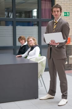 Three business professionals in an office, during a meeting.