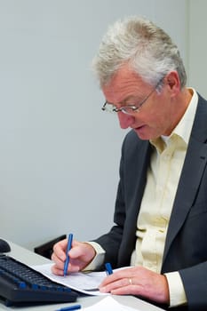 Consultant working on some paperwork on his desk.