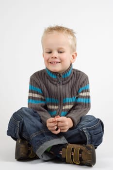 Cute little boy sitting crosslegged