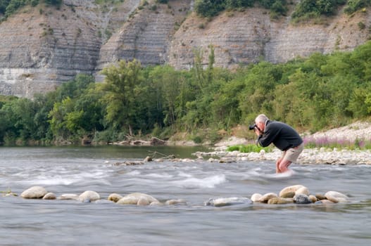 Photographer risking his camera in the stream of the Ardeche, France