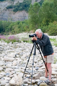 Senior photographer taking pictures of the beautiful nature of the Ardeche in France