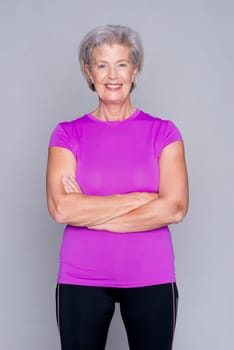 Studio recording of an active senior woman playing sports against a grey background