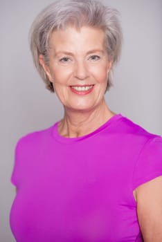 Studio recording of an active senior woman playing sports against a grey background
