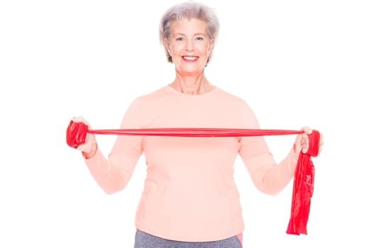 Studio recording of an active senior woman playing sports against a white background