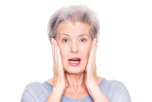 Astonished elderly woman in front of white studio background