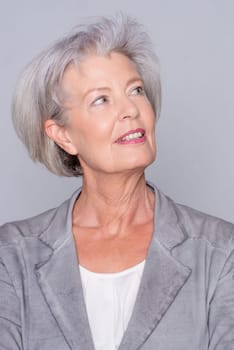 Studio recording of an active senior woman against a grey background