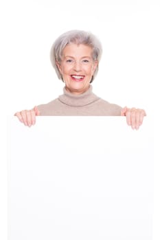 Smiling senior woman with an empty advertising sign against a white background