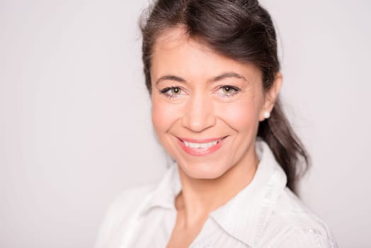 Smiling businesswoman against a grey background