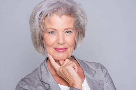 studio shot of an active senior citizen in front of gray background