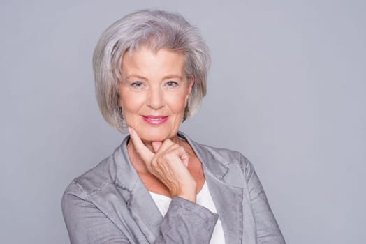 studio shot of an active senior citizen in front of gray background