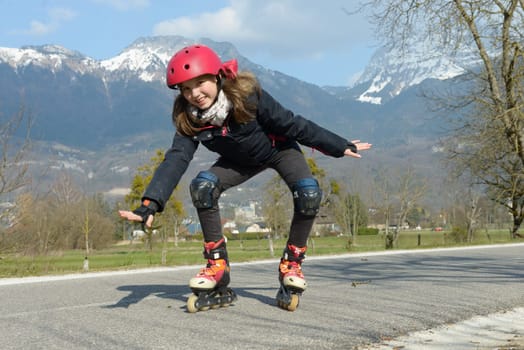 a pretty preteen girl on roller skates in helmet at a track
