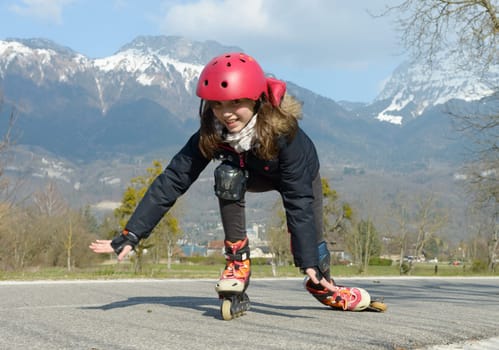 a pretty preteen girl on roller skates in helmet at a track