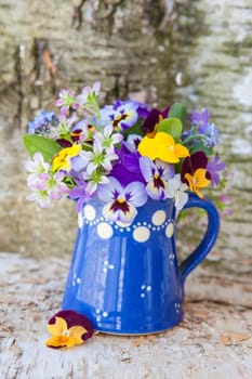 Colourful Strauss frugal flowers in small blue jug