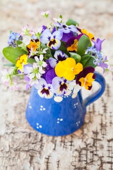 Colourful Strauss frugal flowers in small blue jug