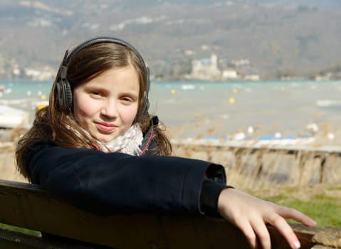 a young teenager listening to music on his phone, outdoor